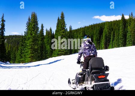 Man Riding Snow Mobile In Winter Wilderness Stock Photo