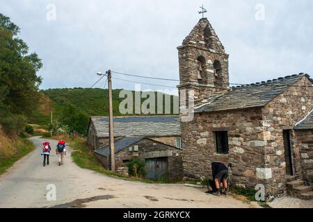 Pilgrim making the route of the Camino de Santiago among the stone houses of the small villages of Galicia. Stock Photo