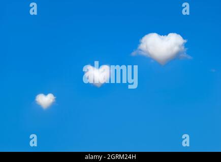 White, fluffy heart shaped clouds in bright blue sky. Concept of love and valentine Stock Photo