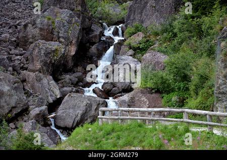 Terminal part of the Pissandolo waterfall in a gorge among the rocks along the road that climbs to the Monte Croce Comelico pass Stock Photo