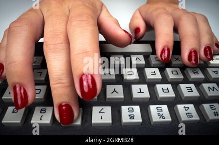 Womans hands typing on computer keyboard Stock Photo