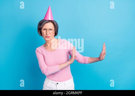 Photo of mature unhappy negative mood woman in cone hat annoyed frustrated isolated on blue color background Stock Photo