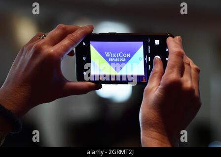 Erfurt, Germany. 01st Oct, 2021. A participant of the annual conference WikiCon takes a photo of the event's logo in the Kaisersaal. This is where Wikipedia's German-speaking volunteer community will meet from October 1 to 3, 2021, to work on current issues and strategic questions about wiki projects. Credit: Martin Schutt/dpa-Zentralbild/dpa/Alamy Live News Stock Photo