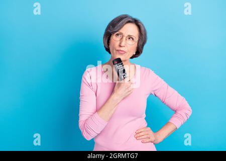 Photo of serious thoughtful minded mature woman in glasses look copyspace thinking isolated on blue color background Stock Photo