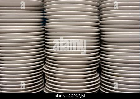 White porcelain plates, stacked on kitchen. Stock Photo
