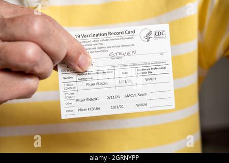 Morgantown, WV - 1 October 2021: Covid-19 vaccination record card showing three doses of Pfizer vaccine including booster shot Stock Photo