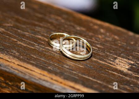 Wedding ring, symbol of love and marriage. Wedding rings creative macro and close up photography. Beautiful golden rings with gems. Stock Photo