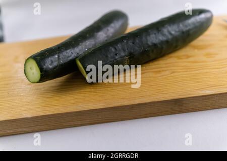 Fresh cucumbers isolated on a wooden cutting board Stock Photo
