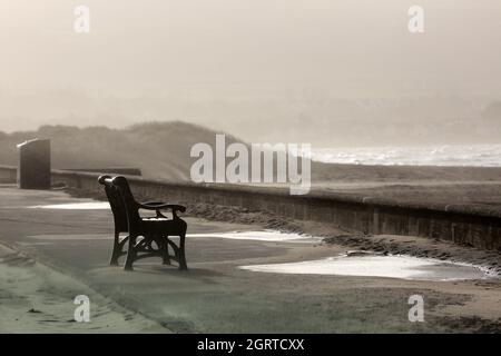 Ayr, Ayrshire, Scotland, A bench sits empty waiting to be used on a wind swept promenade Stock Photo