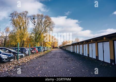 POZNAN, POLAND - Nov 12, 2017: A footpath between a row of locked garage doors and a secured parking lot Stock Photo