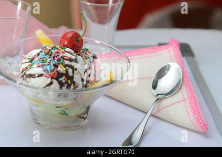 Vanilla Ice Cream with Chocolate Syrup and sprinkles in a glass bowl. Close up. Stock Photo