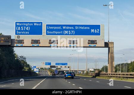 UK motorway, road sign showing directions to A 574 Warrington West and M62 Liverpool, Widnes, St Helens, Southport (M57) Stock Photo