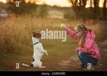 Beautiful girl with Down syndrome with her pet Jack Russell terrier runs to race Stock Photo
