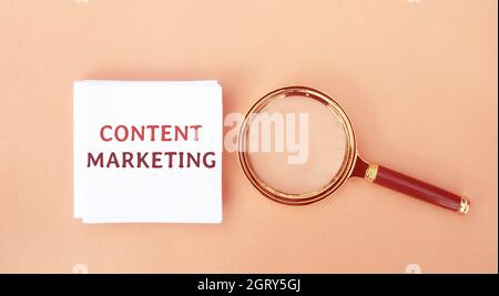 Notes with the words Content Marketing and a magnifying glass. Strategic marketing approach that aims to create relevant content to attracting audienc Stock Photo