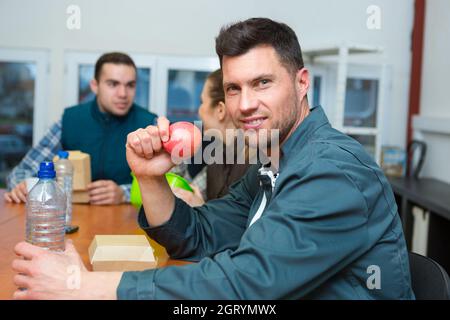 portrait of manual worker eating apple on lunch break Stock Photo