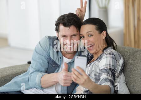 couple striking a funny pose for a smartphone selfie Stock Photo