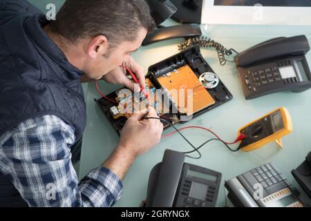 engineer using multimeter to test a telephone Stock Photo