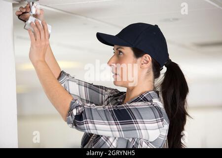 professional female worker installing cctv camera Stock Photo