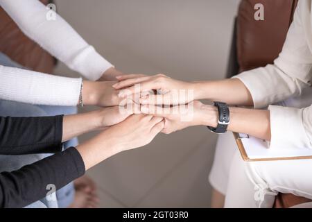 Female Southeast Asian psychologist doctor consults in a psychotherapy session with two females Stock Photo