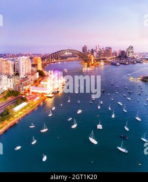 Sunset aerial view over Lavender bay on Sydney harbour towards city waterfront landmarks around the Harbour bridge. Stock Photo