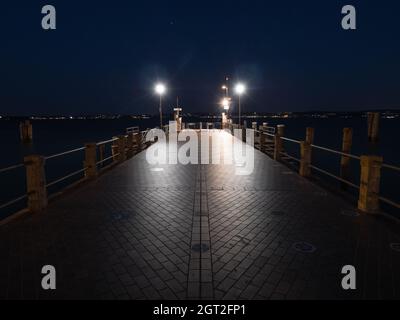 Sirmione Ferry Terminal Jetty on Lake Garda Illuminated at Night Stock Photo