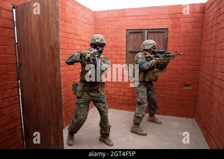 U.S. Marines with Special Purpose Marine Air-Ground Task Force – UNITAS, breach a room during a military operations in urbanized terrain training evolution at Peruvian Marine Corps Base Ancon, Peru, Sept. 26, 2021, during exercise UNITAS LXII. The service members completed a series of training events in order to build trust, enhance confidence and strengthen interoperability to better prepare us for a combined, multinational response to emerging crises or natural disasters. UNITAS is the world's longest-running annual multinational maritime exercise that focuses on enhancing interoperability a Stock Photo