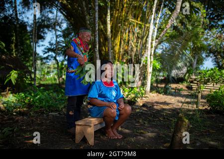 Nueva Loja, Sucumbios / Ecuador - September 2 2020: Elderly indigenous shaman of Cofan nationality performing healing ritual to a Cofan woman in the A Stock Photo