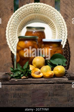 Jars Of Apricot Jam With Mint On An Old Wooden Box On A Weathered Wooden Background