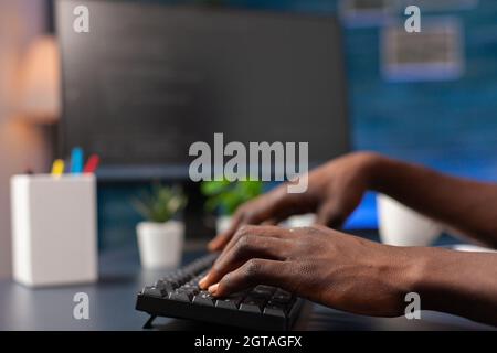Closeup of african american employee hand programming binary code using network security system working remote from home. Programmer man browsing business server on computer. Security software Stock Photo