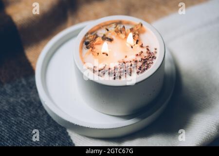 Burning candle with two wicks, handmade candle in white jar Stock Photo