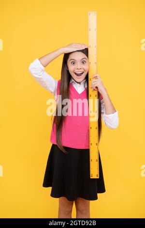 https://l450v.alamy.com/450v/2gtd92b/surprised-kid-girl-use-ruler-to-measure-the-height-measurement-2gtd92b.jpg