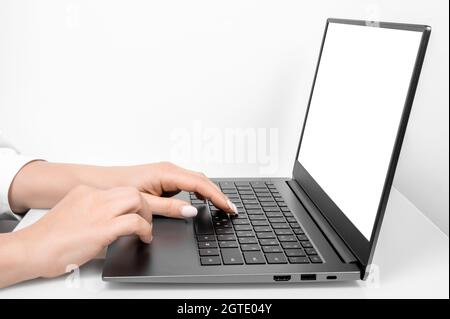 Business woman hands using mockup laptop with white blank screen. side view. blank screen laptop computer template.Notebook screen for application use Stock Photo