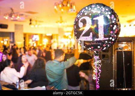21 birthday balloon with party in the background Stock Photo