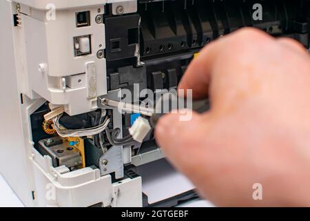 view of the tip of the screwdriver and the printer screw Stock Photo