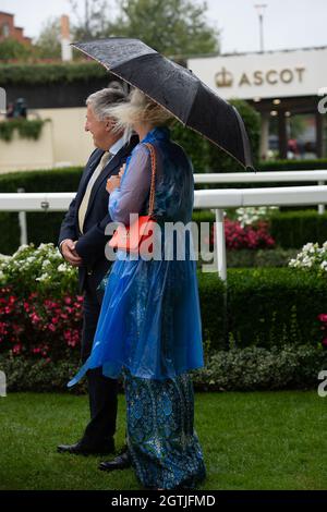 Ascot, UK. 2nd October, 2021. A lady wears a blue raincoat in the Parade Ring at Ascot Races Credit: Maureen McLean/Alamy Live News Stock Photo