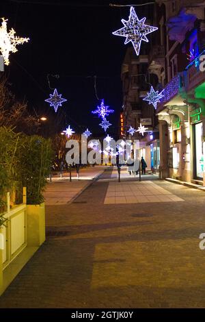 Christmas has arrived, a street festively decorated with splendid blue, white and yellow Christmas lights Stock Photo