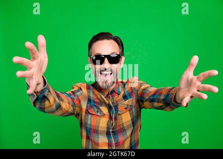 Portrait of attractive cheerful man fooling dancing having fun resting isolated over bright green color background Stock Photo