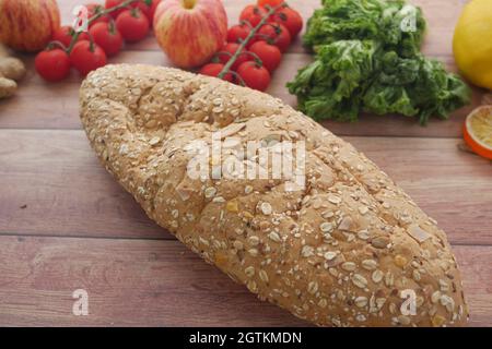 whole meal bread, apple and cherry tomato on table  Stock Photo