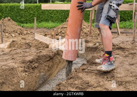 Construction Workers Pouring Concrete - Bricklayers And Concrete Workers Stock Photo