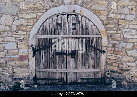 wooden cellar door in a stone wall Stock Photo