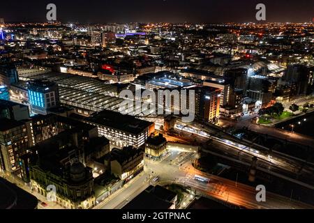 Glasgow, Scotland, UK. 29 September 2021 PICTURED:  Glasgow Central Station seen from the air at night. Glasgow Central connects trains to the West of Scotland and has a direct link with London down the West Coast line.  Aerial night drone view of Glasgow City Centre showing the lit up streets and the lights and coloured neon light shining and reflecting off of the glass exterior of the buildings.  Credit: Colin Fisher Stock Photo