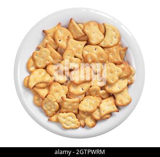 Small salty crackers of different shapes in plate isolated on white background, top view Stock Photo