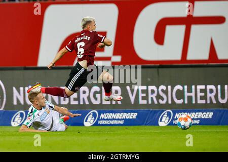 Nuremberg, Germany. 02nd Oct, 2021. Football: 2nd Bundesliga, 1. FC Nürnberg - Hannover 96, Matchday 9, Max-Morlock-Stadion. Nuremberg's Lino Tempelmann (r) jumps over the straddling Hannover player Jannik Dehm. Credit: Löb Daniel/dpa - IMPORTANT NOTE: In accordance with the regulations of the DFL Deutsche Fußball Liga and/or the DFB Deutscher Fußball-Bund, it is prohibited to use or have used photographs taken in the stadium and/or of the match in the form of sequence pictures and/or video-like photo series./dpa/Alamy Live News Stock Photo