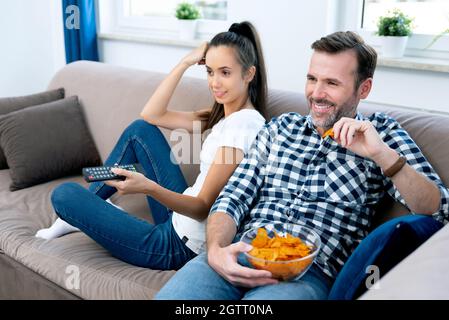 Couple watching TV on sofa. Television, multimedia, leisure concept Stock Photo