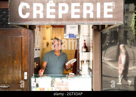 PARIS, FRANCE - Sep 20, 2021: A man working at a creperie in Paris