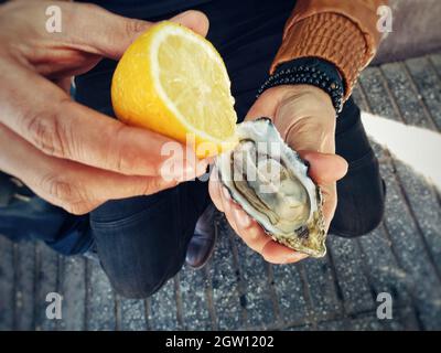 View Of A Man Try To Eat Fresh Oyster With Lemon