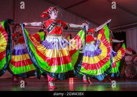 Uyghur folk dancers from the Xinjiang region of China performing on stage in traditional costume during Moon Festival celebrations. Auckland, NZ Stock Photo