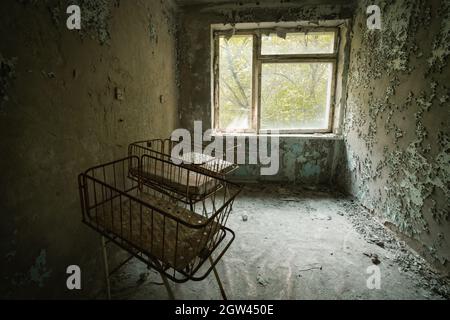 Cribs at the Nursery of Pripyat Hospital - Pripyat, Chernobyl Exclusion Zone, Ukraine Stock Photo