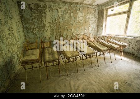 Cribs at the Nursery of Pripyat Hospital - Pripyat, Chernobyl Exclusion Zone, Ukraine Stock Photo