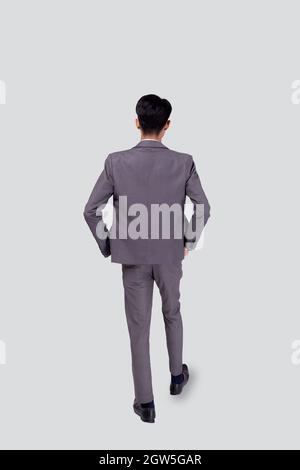 Back view young asian business man in suit walking isolated on white background, portrait of executive or manager, happy businessman handsome and smar Stock Photo